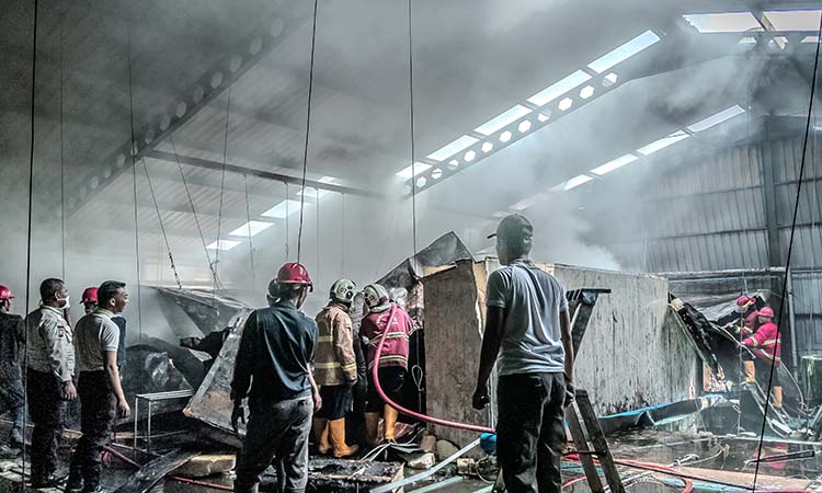 PEMBASAHAN: Personel damkar melakukan upaya pemadaman kebakaran gudang cold storage di PT Winaros Kawula Bahari, Desa Cangkringmalang, Kecamatan Beji.