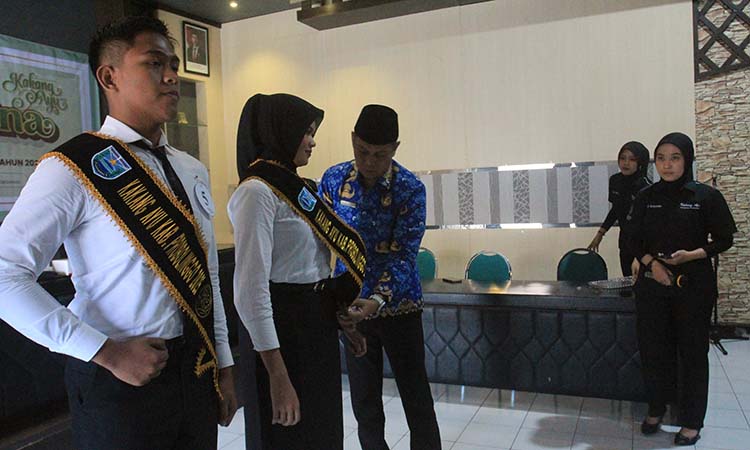 SIMBOLIS:  Kepala Dinas Kepemudaan, Olahraga dan Pariwisata (Dispopar) Kabupaten Probolinggo, Heri Mulyadi, memakaikan selempang Kakang Ayu kepada peserta, (2/6).