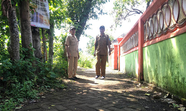 NYAMAN: Sekretaris Desa Pohsangit Tengah, Suyono (kanan) dan Kaur Pembangunan Desa Pohsangit Tengah, Mari (kiri) di lokasi pembangunan pavingisasi Dusun Krajan, Desa Pohsangit Tengah.