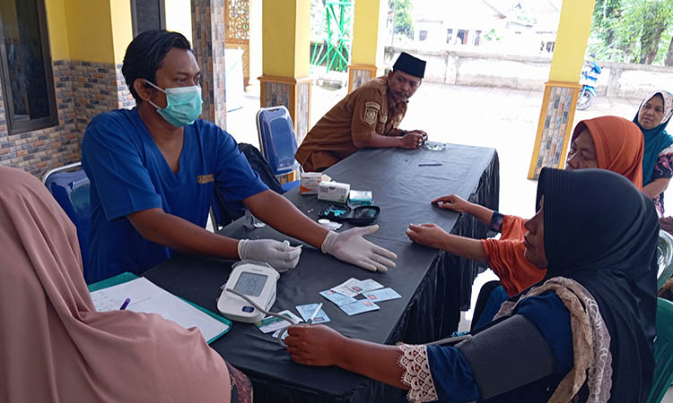 POSYANDU: Perawat Desa Pohsangit Ngisor, Wahyu Riguk (bermasker) saat memeriksa warga di Posyandu Desa Pohsangit Ngisor, Kecamatan Wonomerto.