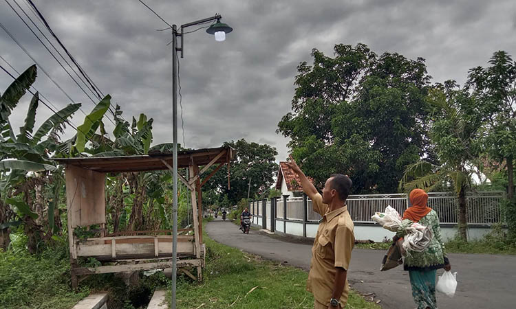 CEGAH KERAWANAN: Perangkat Desa Leces saat menujukkan PJU yang sudah terpasang di Dusun Dukbulu.
