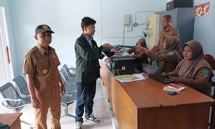 OPTIMAL: Kepala Desa Glagah, Abdur Rahman&nbsp; (kiri) saat memantau langsung pelayanan di ruang pelayanan baru desa setempat.