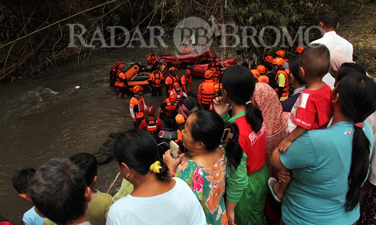 BIKIN PENASARAN: Warga berkerumun menyaksikan rombongan Wali Kota Pasuruan Adi Wibowo dan personel BPBD yang melakukan susur sungai Gembong, Kamis (19/6). (Mokhamad Zubaidillah/ Radar Bromo)