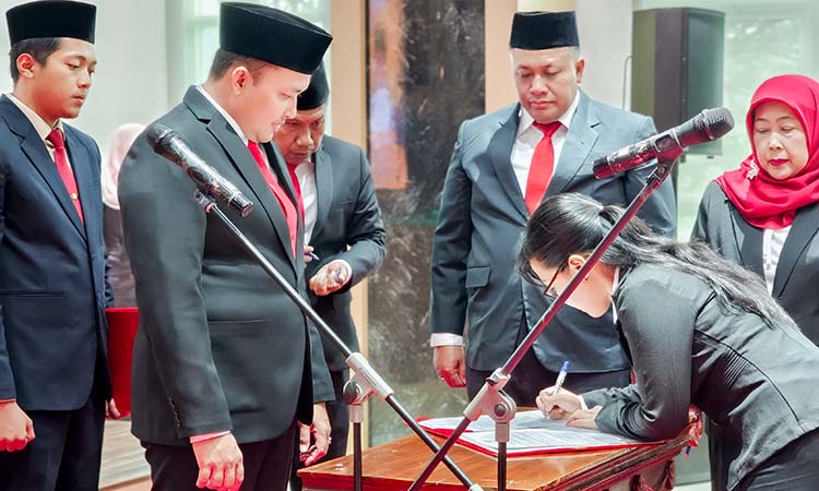 Bupati Pasuruan Mas Rusdi saat melihat salah satu guru yang dilantik jadi kepala sekolah menandatangani berkas.
