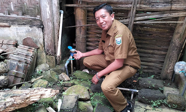 TERKONTROL: Bendahara Desa Sariwani Fitra Ardi Wicahya mengecek watermeter di Dusun Kertowani.