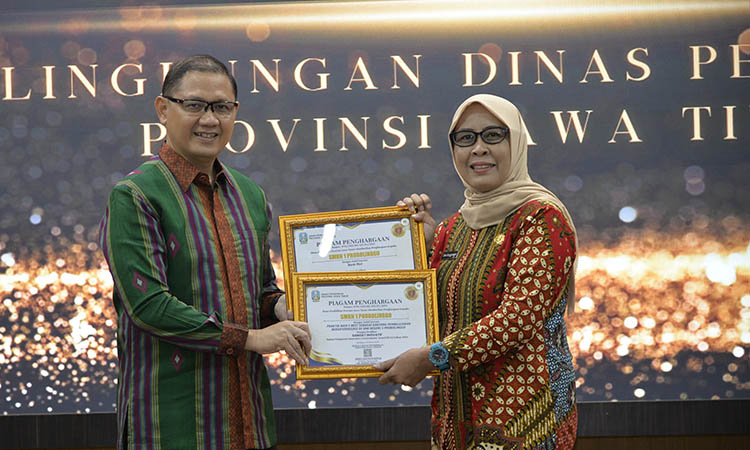 PENGHARGAAN TERTINGGI: Kepala SMKN 1 Probolinggo Dwi Anggraeni menerima piagam penghargaan tertinggi IGA 2024 dari Kepala Dinas Pendidikan Provinsi Jatim Aries Agung Paewei di Gedung Sabha Nugraha, Ka