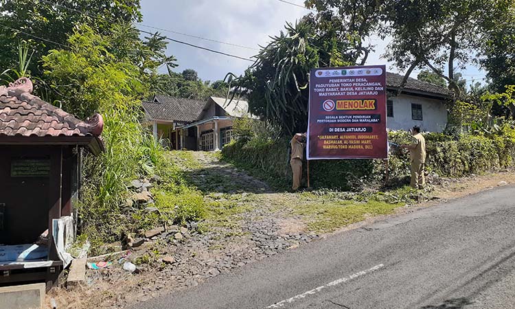 MANDIRI: Spanduk Tolak Toko Waralaba yang dipasang di jalan-jalan Desa Jatiarjo, Kecamatan Prigen.