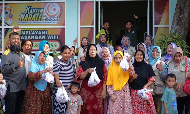 BERBAGI: Manajer Area Kapten Naratel Pasuruan Ferdi Fauzi (kiri) memberikan paket daging kurban kepada masyarakat di sekitar Kantor Kapten Naratel di Jalan Margoutomo, Kota Pasuruan.
