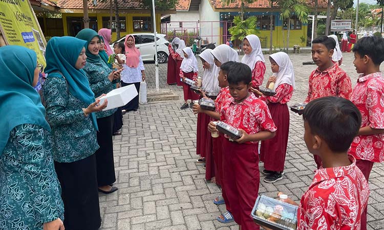 SEHAT: Esti Alfianing Tyas, A.Md.Keb (tengah) membagikan Pemberian Makanan Tambahan Anak Sekolah (PMT-AS) bagi siswa SD.