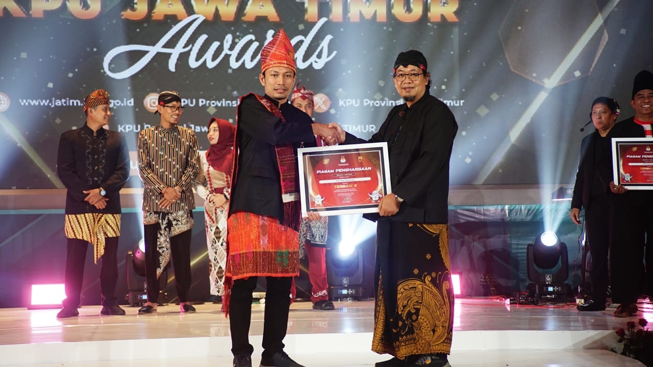 PENGHARGAAN: Radfan Faisal saat menerima penghargaan kategori Sosialisasi dan Keterbukaan Informasi Publik yang diterima dari KPU Provinsi Jawa Timur serta Komisi Informasi Jawa Timur.