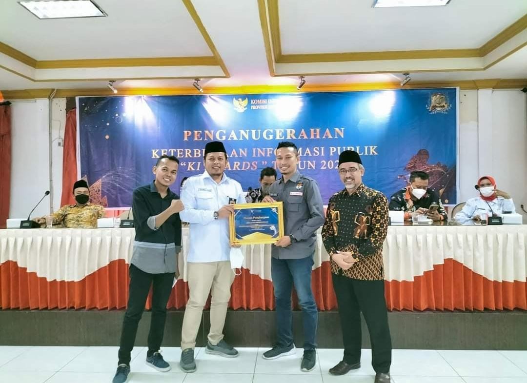 PENGHARGAAN: Radfan Faisal saat menerima penghargaan kategori Sosialisasi dan Keterbukaan Informasi Publik yang diterima dari KPU Provinsi Jawa Timur serta Komisi Informasi Jawa Timur.