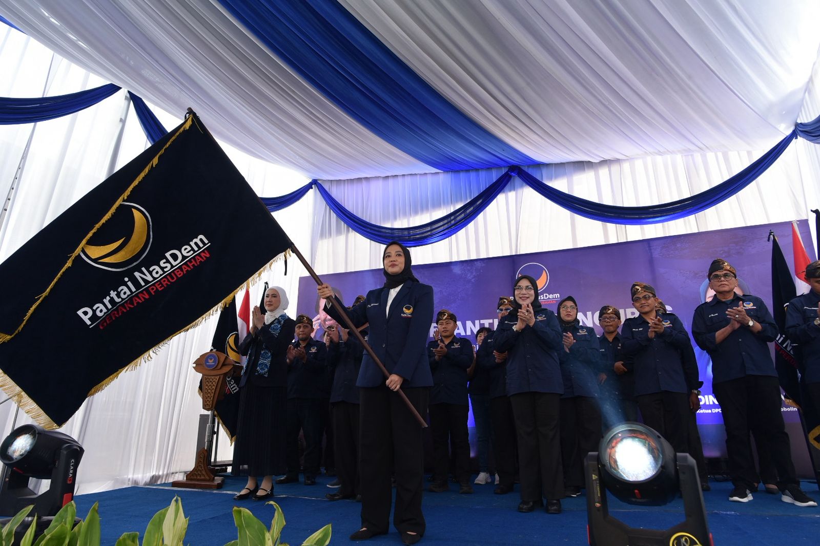 BERKIBAR: Ketua DPD NasDem Kabupaten Probolinggo Hj. Dini Rahmania mengibarkan bendera pataka Partai NasDem.
