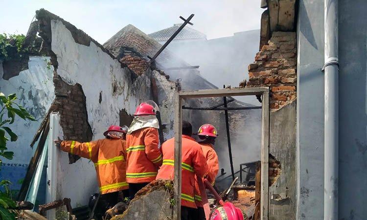 PADAMKAN: Petugas Damkar Kota Pasuruan saat berjibaku untuk menjinakkan api yang membakar rumah tak berpenghuni.