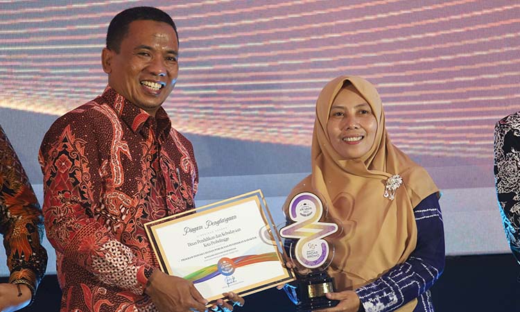 Kepala Disdikbud Kota Probolinggo Siti Romlah (kanan) saat menerima Radar Bromo Awards 2025 dari Direktur Jawa Pos Radar Bromo HA Suyuti.