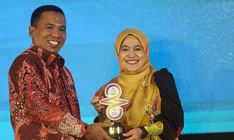 Ketua TP PKK Kota Pasuruan Suryani Firdaus Adi Wibowo  (kanan) saat menerima trofi RBA 2025 dari Direktur Radar Bromo.