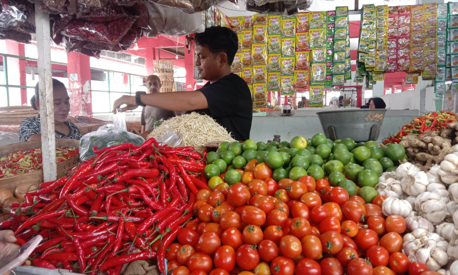 LAYANI PEMBELI: Salah seorang pedagang di Pasar Gotong Royong Kota Probolinggo, melayani pembeli. Sejak belum terakhir, harga cabai dan tomat di Kota Probolinggo, terus meninggi.