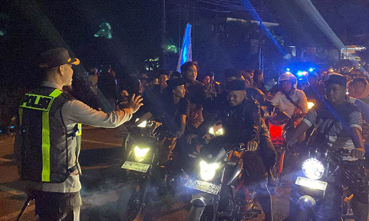 KAWAL: Petugas kepolisian saat melakukan pengawalan jalannya pengesahan anggota salah satu perguruan silat di wilayah Kota Pasuruan. Hal ini dilakukan, untuk menjaga kondusivitas wilayah.