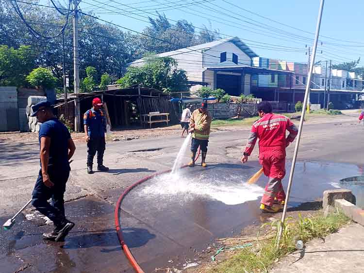 SEMPROT: Tim Damkar Satpol PP Kota Probolinggo membersihkan tumpahan oli di Simpang Empat Pasar Kronong, Kota Probolinggo, Rabu (9/7).