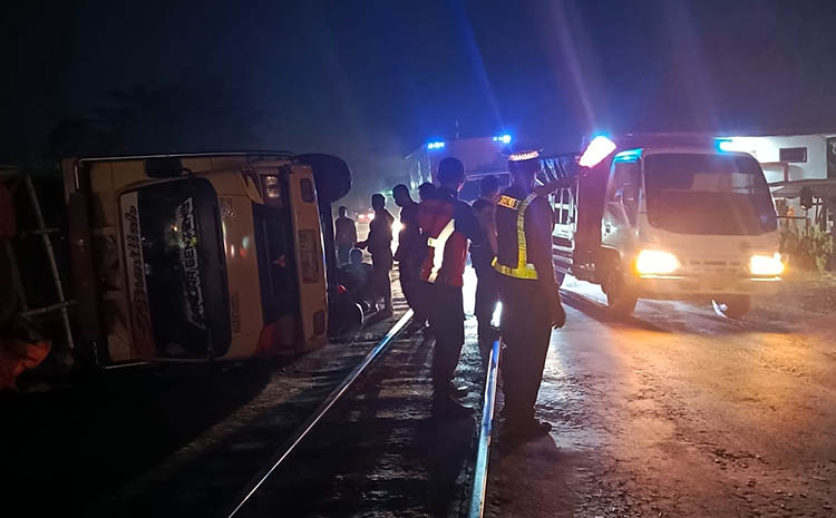 TERGULING: Truk pengangkut gabah yang terguling saat melintas di perlintasan KA Mangkrengan. Selain jalan bergelombang, muatan yang terlalu berat disebut-sebut menjadi faktor pemicu kecelakaan.