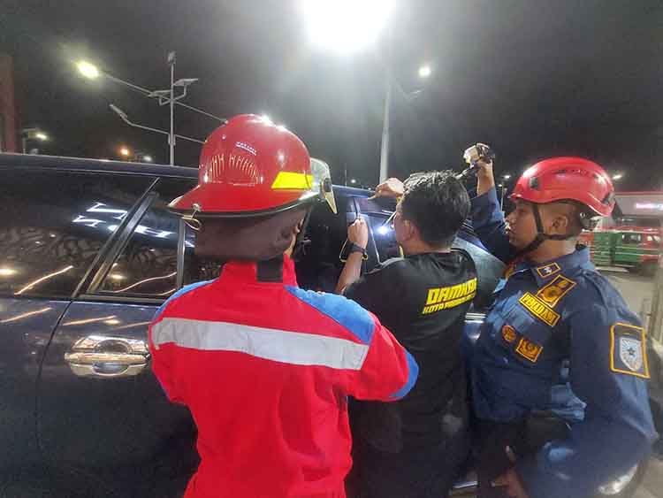 BERTUGAS: Tim Damkar Satpol PP Kota Probolinggo membantu mengambil kunci mobil yang ada di jok di tempat parkir salah satu toko pakaian di Kota Probolinggo, Jumat (11/7)