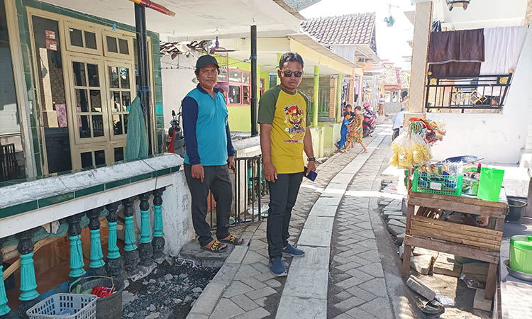SUDAH LEBIH MULUS: Kepala Desa Kalibuntu, Khairul Anam (berkacamata) saat melihat pembangunan paving di desanya.