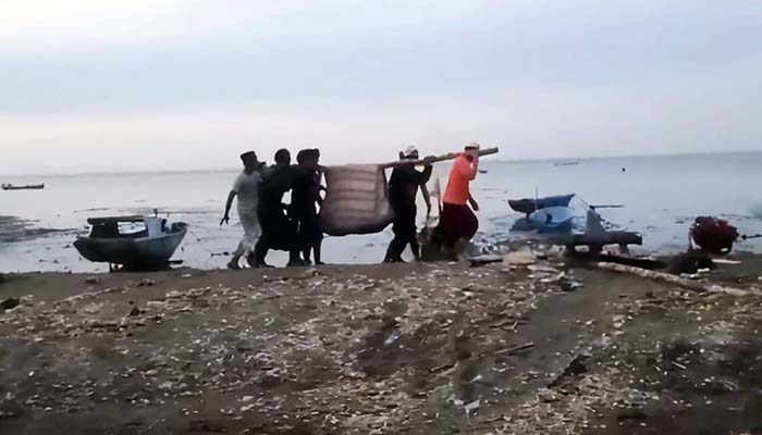 EVAKUASI: Petugas dibantu warga mengevakuasi jenazah penumpang perahu yang terbalik di perairan Lekok, Pasuruan, Senin (14/7). (Istimewa)