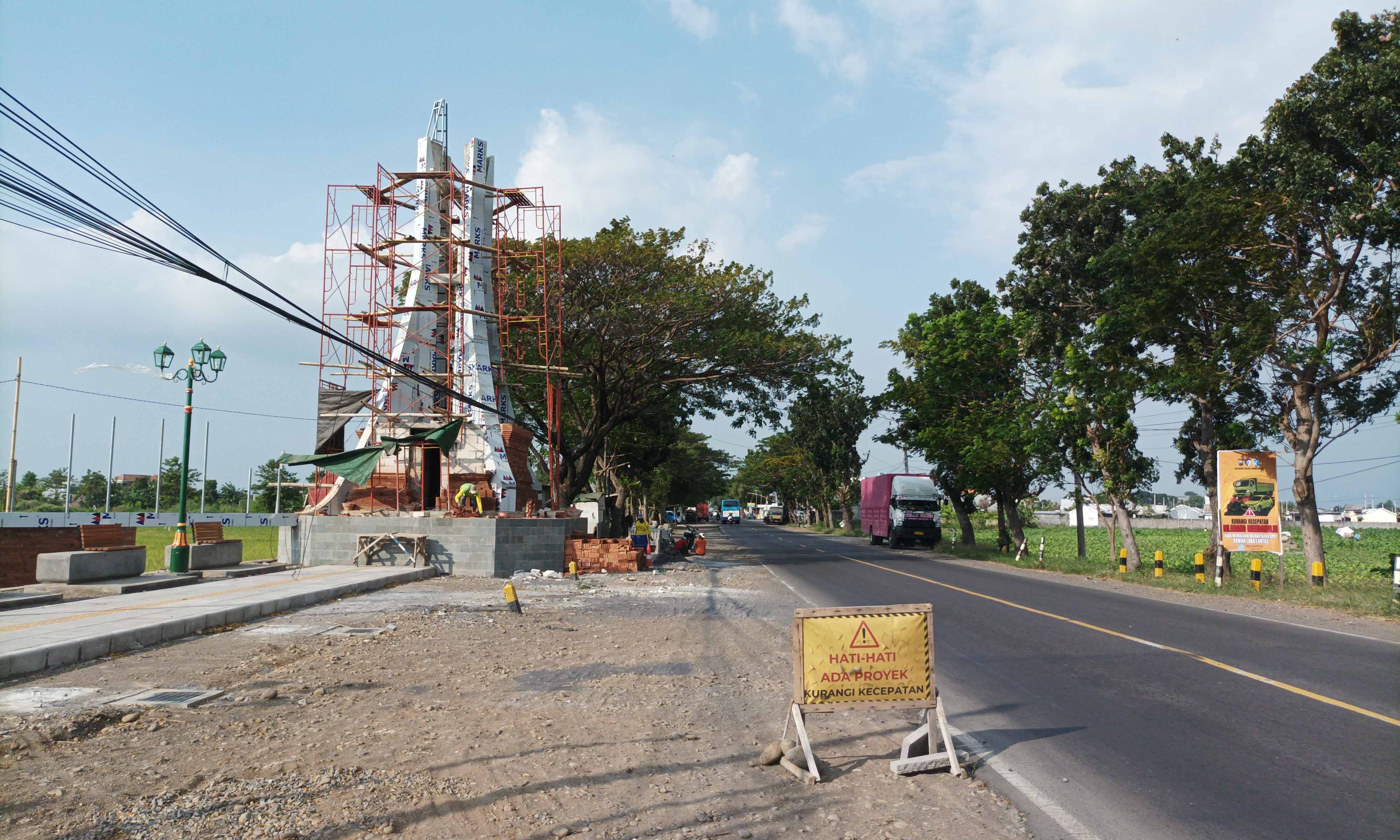 PROSES: Sejumlah pekerja menggarap pembangunan Gapura Kota Kraksaan di Jalur Pantura Kecamatan Pajarakan.