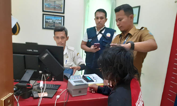 DIAMANKAN: Petugas melakukan pemindaian biometrik ODGJ di Kantor Kecamatan Paiton. Setelah teridentifikasi dipulangkan ke tempat asal.