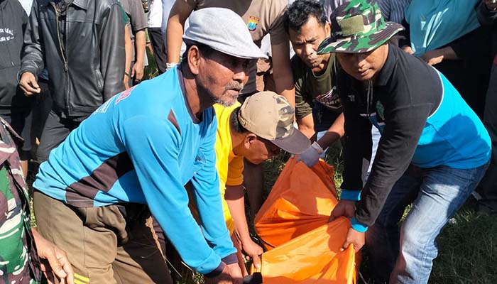 KORBAN PEMBUNUHAN: Warga mengevakuasi korban pembunuhan yang jenazahnya dibuang di sungai Payaman, Sukodermo, Purwosari, Pasuruan, Jumat (18/7). (Rizal Syatori/ Radar Bromo)