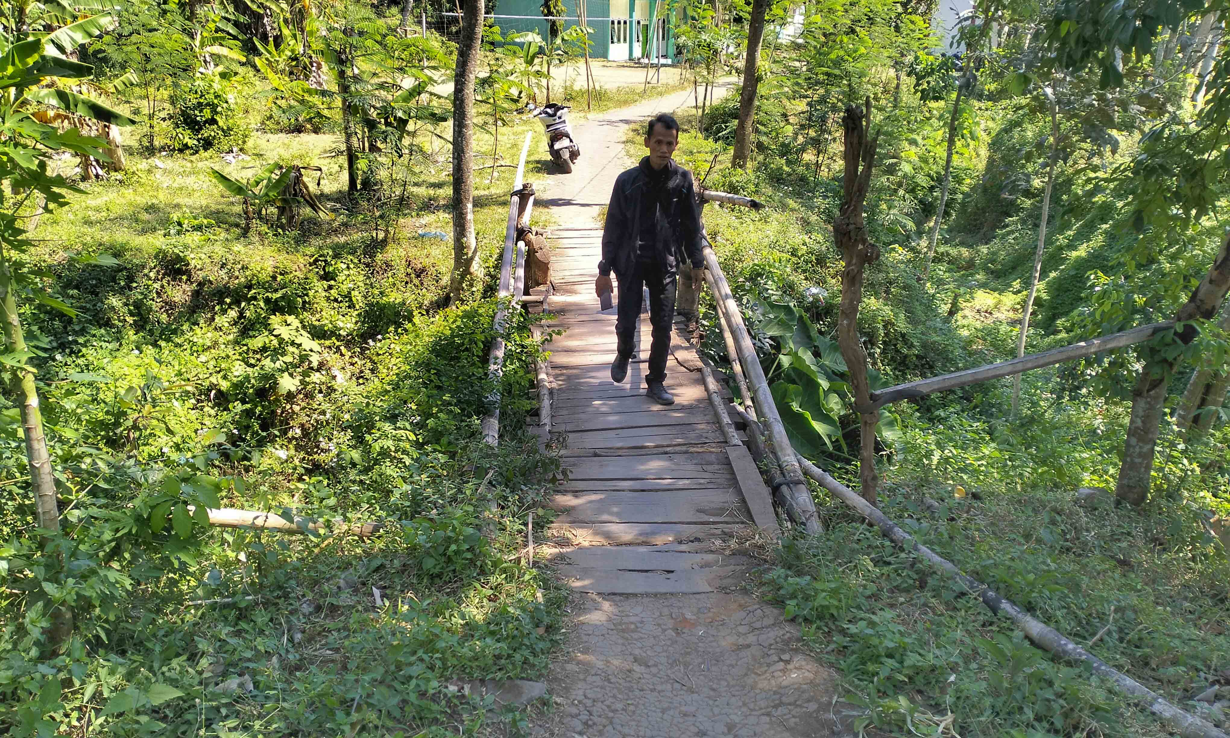 SEGERA DIBANGUN: Bendahara Desa Bulujaran Kidul Marzuki melintas di jembatan di RT 14/RW 2, Dusun Kosambi, yang akan dibangun.