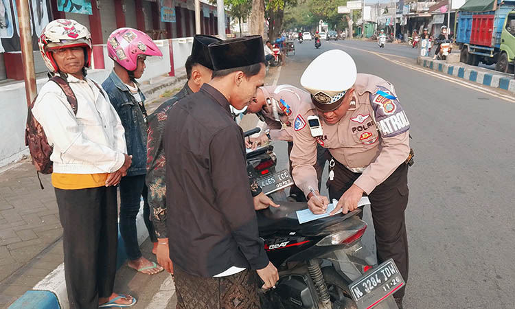 DITILANG: Petugas Satlantas Polres Pasuruan Kota saat menindak pelanggar roda dua yang tidak memakai helm.