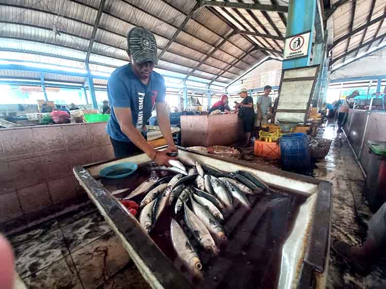 DAGANG: Seorang pedagang ikan saat menggelar dagangannya di Pasar Ikan Mayangan, Kota Probolinggo, Kamis (17/7).