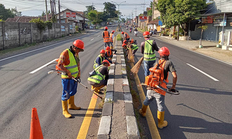 BERSIHKAN: Sejumlah pekerja saat melakukan pembersihan median jalan. Langkah ini dilakukan, agar pengendara aman dan nyaman.