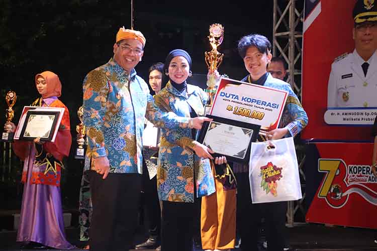 DUTA KOPERASI: Wali Kota Probolinggo dr. Aminuddin didampingi Ketua TP PKK dr. Evariani menyerahkan trofi piagam penghargaan dan slempang kepada Duta Koperasi 2025, peserta nomor urut 6, Imanuel Krist