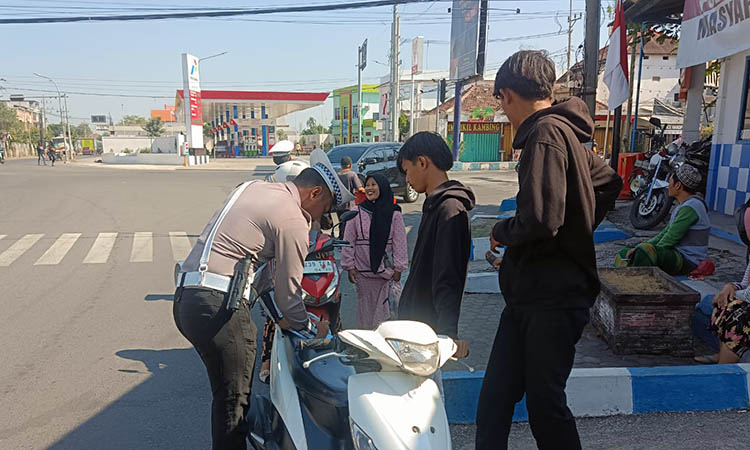 TILANG: Petugas kepolisian saat menilang pengendara yang melanggar.