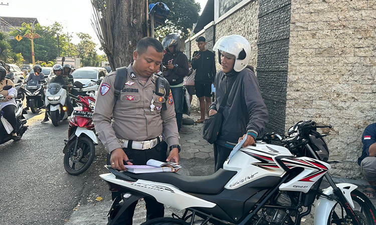 OPERASI: Personel Satlantas Polres Probolinggo Kota menindak pelanggar di simpang empat Randu Pangger, Wiroborang.