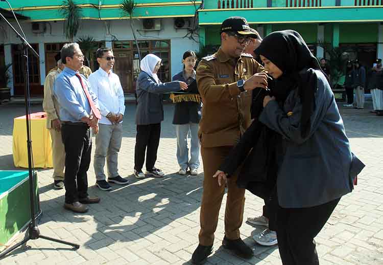 SIMBOLIS: Bupati Probolinggo dr. Mohammad Haris&nbsp; menyematkan jaket KKN kepada perwakilan mahasiswa.