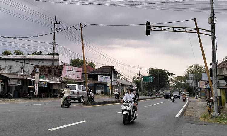 MIRING: Dua tiang TL yang kondisinya miring. Meski rawan roboh, keberadaan tiang tersebut tak kunjung mendapat pembenahan.