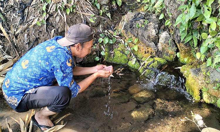 SEGAR: Kepala Desa Lemahbang, Naqso Bandi saat menikmati kesegaran air Sumber Megalawu. Keberadaan sumber tersebut seolah menjadi berkah bagi warga sekitar.