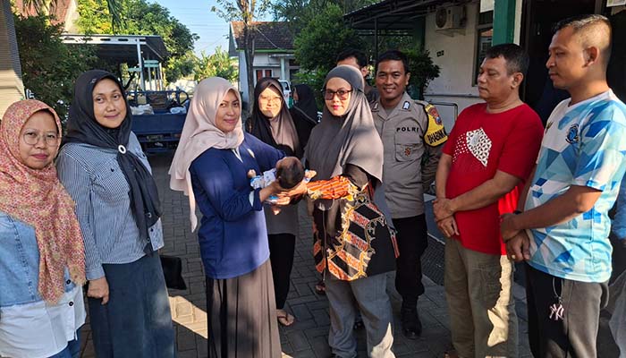 Staf Dinas Sosial, PPPA Kota Probolinggo menyerahkan bayi perempuan yang ditemukan di teras rumah Sutiah pada LKSA Panti Asuhan Al Umah, Sabtu (2/8).