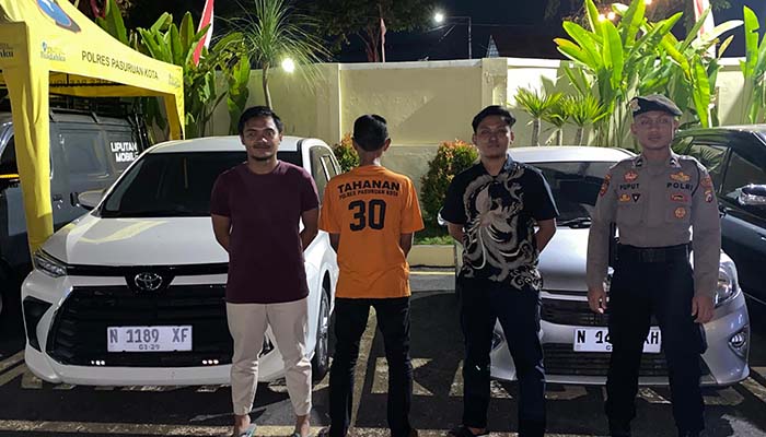 AY, Kepala Desa Karangpandan, Kecamatan Rejoso, Kabupaten Pasuruan (membelakangi kamera) saat dikeler petugas bersama BB mobil.