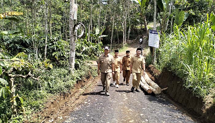 LEBIH AMAN: Kepala Desa Roto Sriyanto (kiri) bersama perangkat desa melintas di jalan RT 4/RW 2, Dusun Kertakata Barat, yang baru selesai dimakadam.