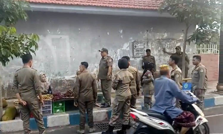 INGATKAN: Petugas Satpol PP Kota Pasuruan saat memberikan sosialisasi kepada PKL yang berjualan di tempat terlarang.