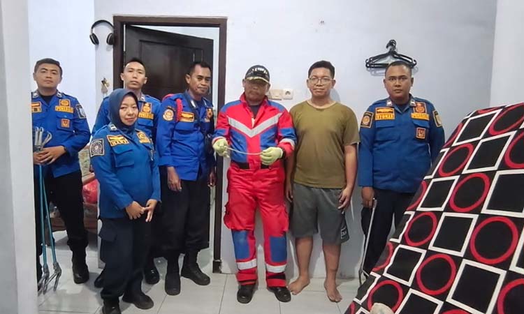 Petugas Damkar Satpol PP Kota Probolinggo saat melakukan evakuasi ular sawah di salah satu rumah warga, Kelurahan Curahgrinting, Kecamatan Kanigaran, Kota Probolinggo.