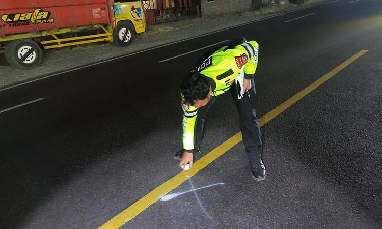TANDAI LOKASI KEJADIAN: Personel Unit Gakkum Satlantas Polres Probolinggo saat melakukan olah tempat kejadian perkara Jumat (8/8) malam di Jalan raya Leces.