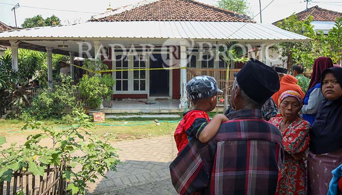 DI-POLICE LINE: Petugas kepolisian memasang police line di rumah korban.
