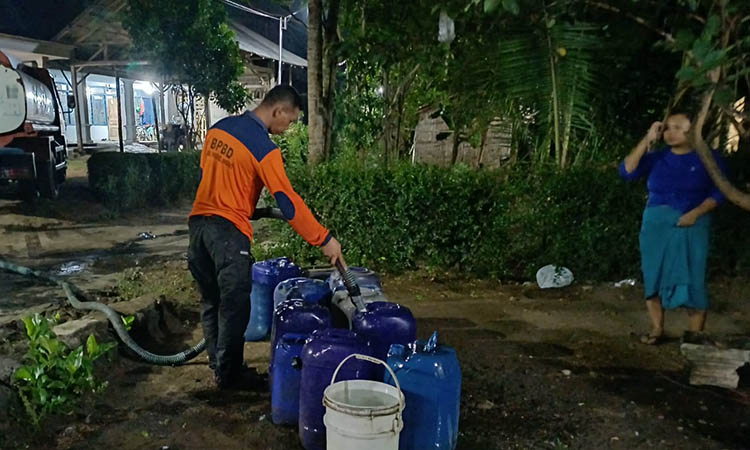 DAMPAK KEMARAU: Personel BPBD saat melakukan distribusi air bersih ke rumah-rumah warga