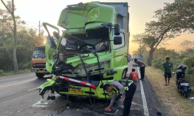 RINGSEK: : Petugas Satlantas Polres Pasuruan saat melakukan olah TKP. Dugaan kuat, kecelakaan itu dipicu karena sopir truk Hino mengantuk.