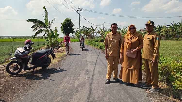 MULUS: Kepala Desa Gending Marito (bertopi) bersama perangkat desa melihat progres pengaspalan jalan di Dusun Buyut RT 10&ndash;11/RW 4.