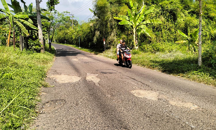 MENGELUPAS: Jalan Pandaan-Ledug, yang mengelupas. Kondisi itu, membahayakan pengguna jalan.